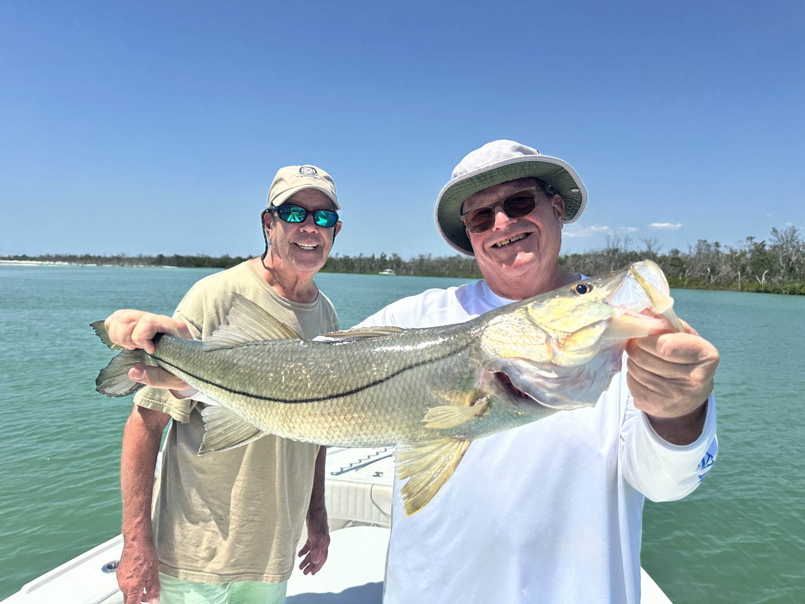 Two smiling anglers with a snook in the backcountry