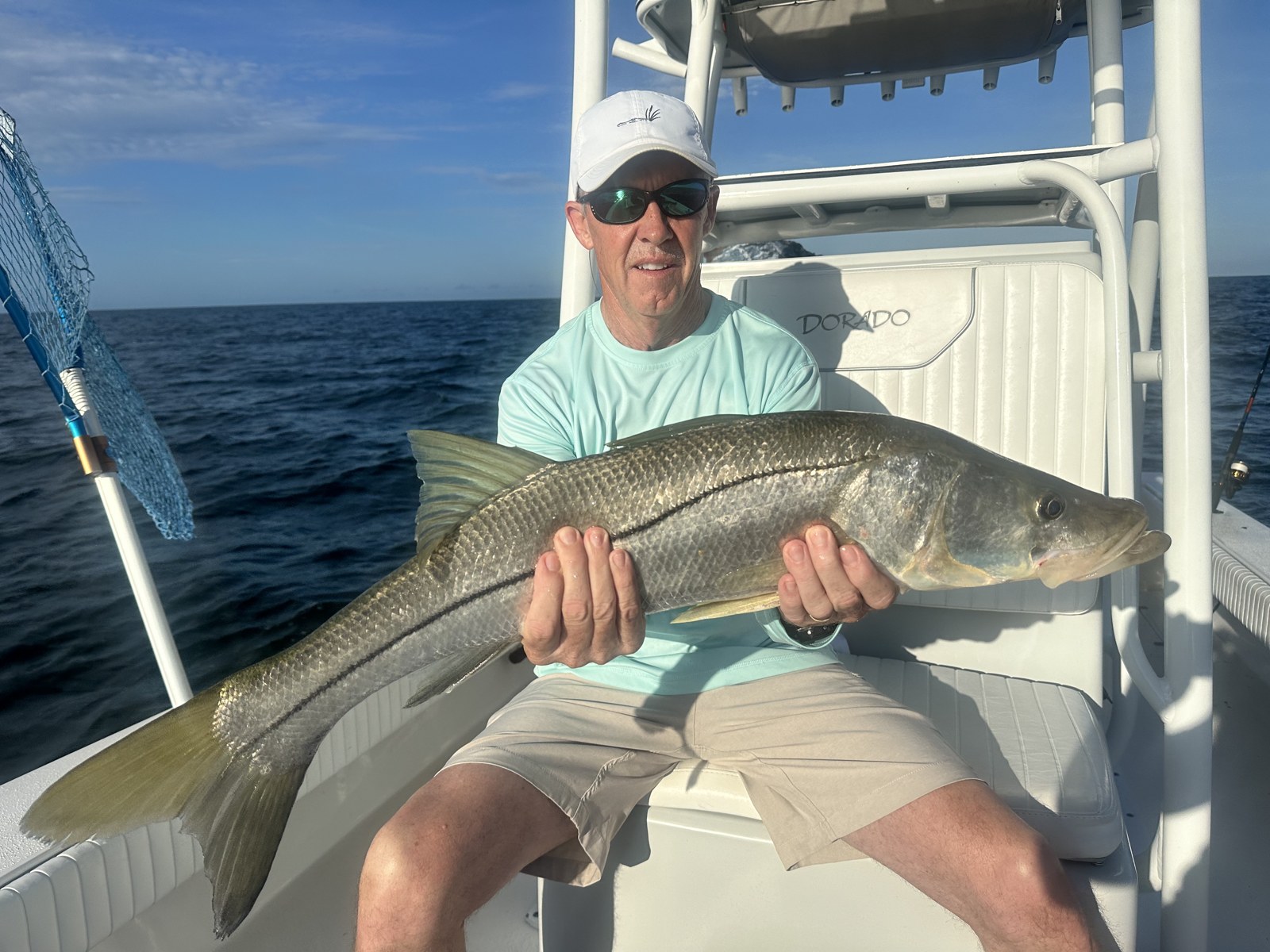 Angler seated on the Dorado with a heavy snook