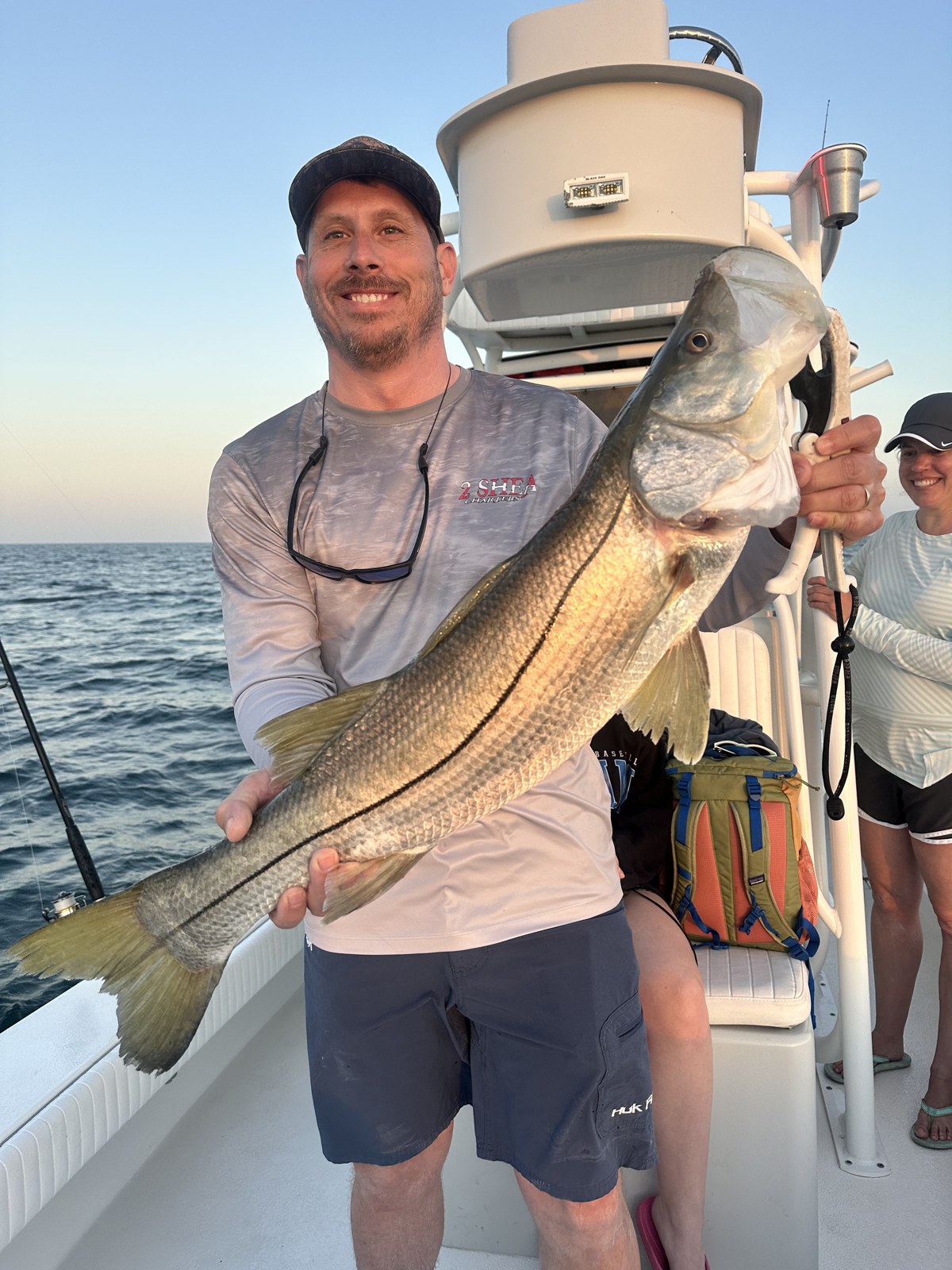 Angler holding a big snook at sunset on the Gulf