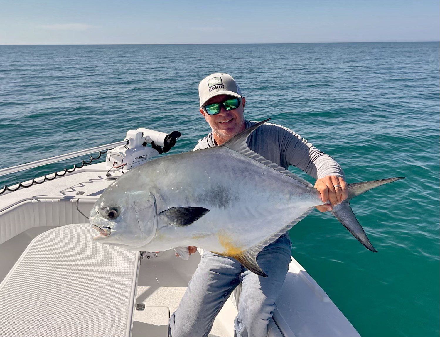 Angler holding a permit caught on the flats