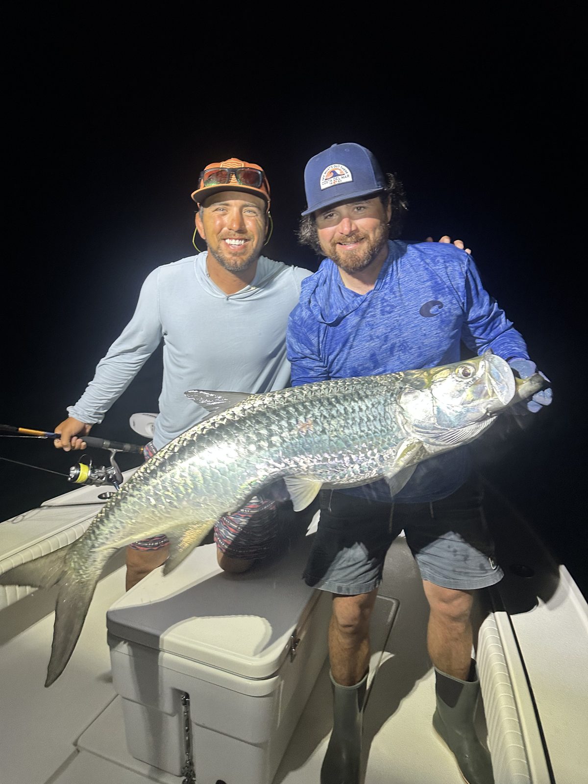 Two anglers with a silver tarpon on a night trip