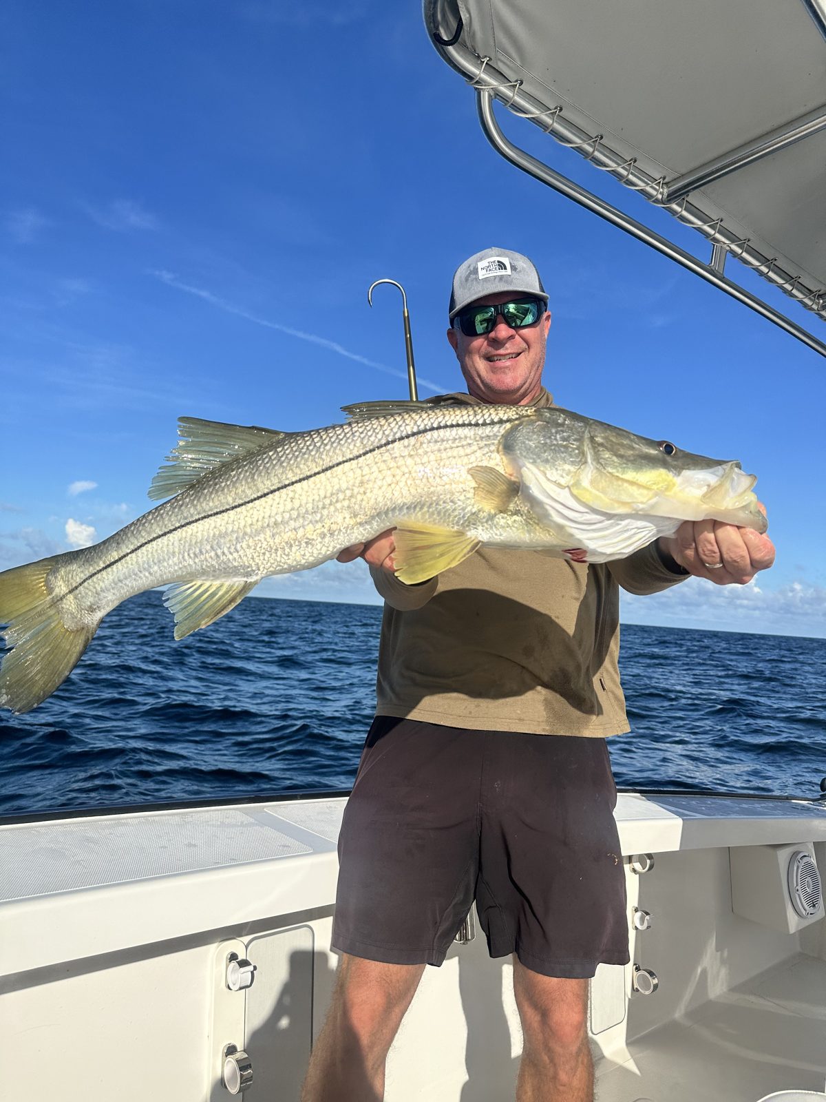 Captain with a trophy snook under blue skies